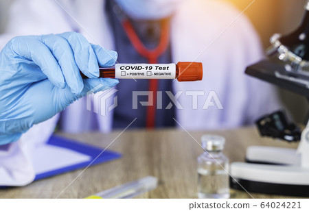 Close up The doctor's hand holds the patient's blood test results to find the Coronavirus or Covd-19 that is an outbreak in Epidemiology or infectious concept with blur background 64024221