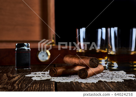 Still life with three cuban cigars, two glasses of 64024258