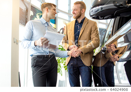 affable handsome consultant and client in dealership affable handsome consultant and client in dealership 64024908