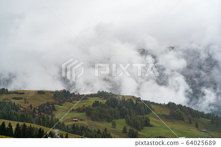 Dolomites mountain landscape cover with low cloud in autumn in Alpe di siusi, Italy Dolomites mountain landscape cover with low cloud in autumn in Alpe di siusi, Italy 64025689