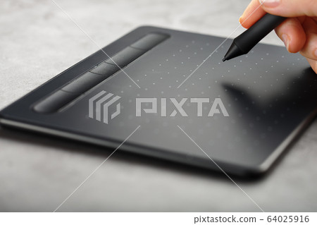 Pen with a graphic tablet in the hands of the Pen with a graphic tablet in the hands of the 64025916