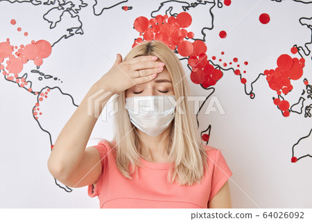female touching forehead during coronavirus spreading 64026092