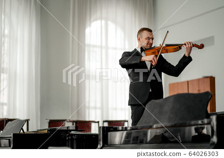 young caucasian violinist play classical instrument young caucasian violinist play classical instrument 64026303