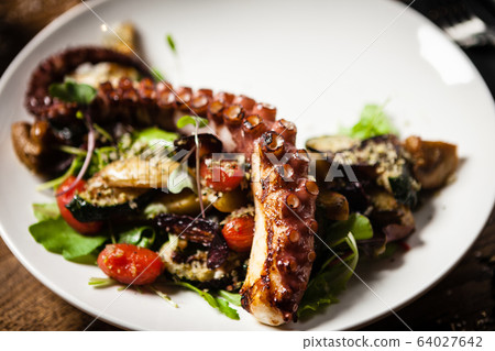 Octopus salad served on a plate in restaurant Octopus salad served on a plate in restaurant 64027642