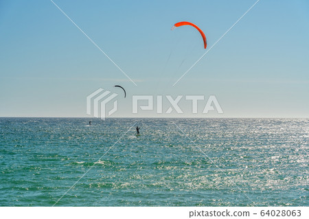 The athlete practices kate board surfing the sea on the waves. Summer in Portugal Algarve. The athlete practices kate board surfing the sea on the waves. Summer in Portugal Algarve. 64028063