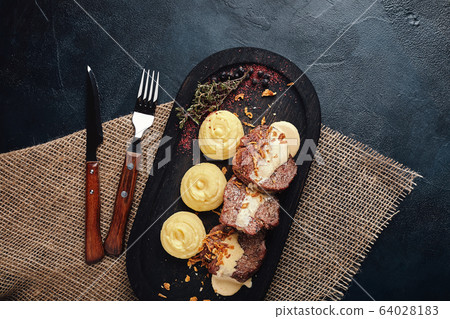 Grilled pork chops with mashed potatoes. On a dark wooden background, rustic style. Food photo. 64028183