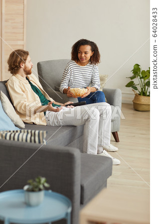 Modern Young Couple Eating Popcorn at Home 64028433