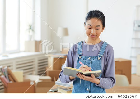Happy Asian Woman Planning Moving to New House Happy Asian Woman Planning Moving to New House 64028567