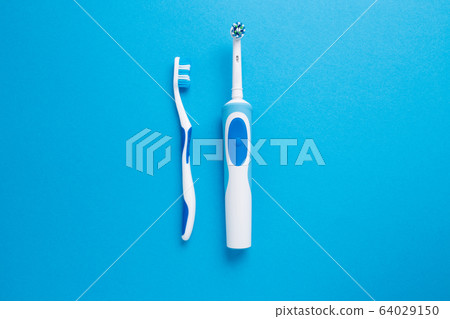 Electric or simple toothbrush on a blue background. Electric or simple toothbrush on a blue background. 64029150