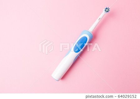 Electric toothbrush on a pink background. Electric toothbrush on a pink background. 64029152