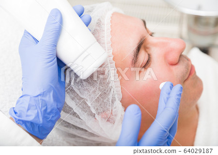 Anti-aging cosmetic mask applying for adult man 64029187