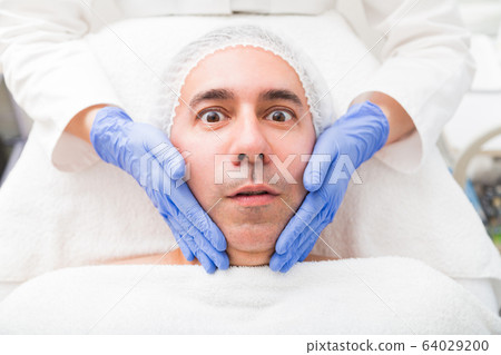 Man having face massage in beauty salon close up 64029200
