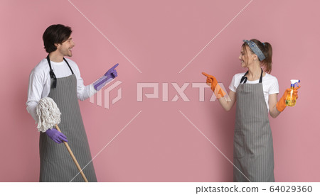Happy Couple With Cleaning Instruments In Hands Pointing At Copy Space 64029360