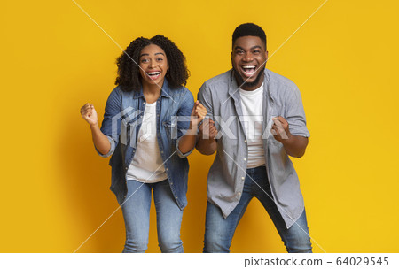 Euphoric Black Couple Cheering With Clenched Fists And Yelling With Excitement 64029545