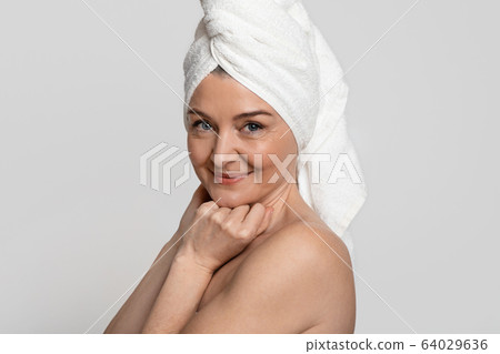 Portrait Of Attractive Nude Middle-Aged Woman With Towel On Head 64029636