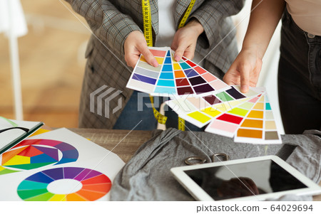 Female fashion stylist and customer holding color samples 64029694