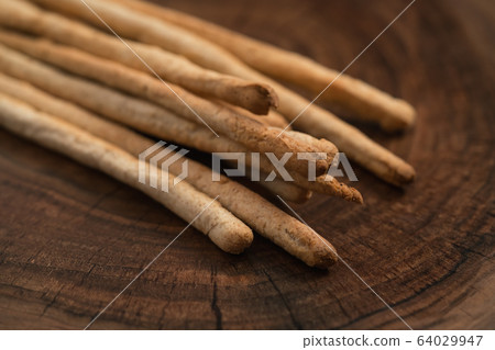 Traditional italian snack - grissini on walnut surface Traditional italian snack - grissini on walnut surface 64029947