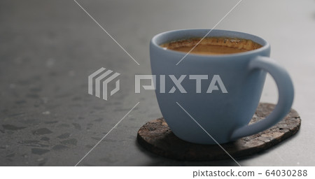 blue cup with fresh espresso on cork coaster on concrete surface blue cup with fresh espresso on cork coaster on concrete surface 64030288