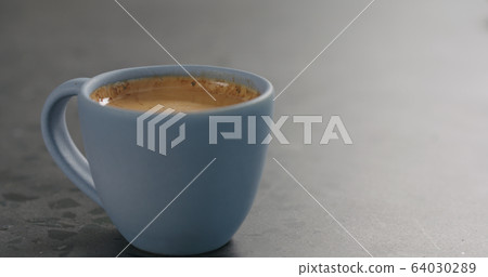 blue cup with fresh espresso on concrete surface 64030289