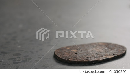 bark cork coaster on concrete surface with copy space 64030291