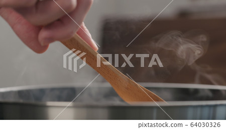 shot of frying turkey fillet pieces on nonstick pan and turning them with wood spatula shot of frying turkey fillet pieces on nonstick pan and turning them with wood spatula 64030326