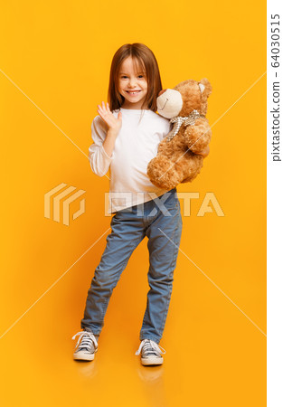 Smiling beautiful girl holding big toy teddy bear Smiling beautiful girl holding big toy teddy bear 64030515