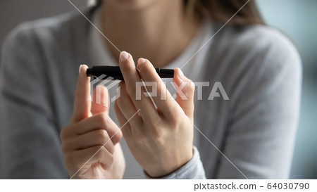 Young woman check sugar level using glucose meter Young woman check sugar level using glucose meter 64030790