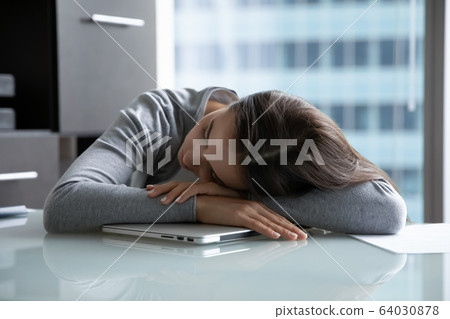 Tired female employee fall asleep at workplace Tired female employee fall asleep at workplace 64030878