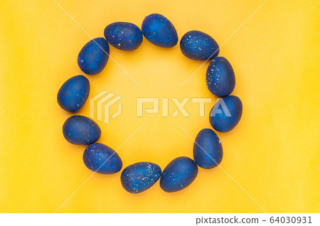 Blue eggs on a yellow background. Circle shape. 64030931