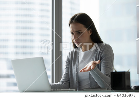 Frustrated female employee having computer problems at workplace 64030975