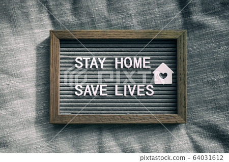 COVID-19 text for self isolation staying at home . Stay home, save lives. Coronavirus quote sboard sign with message of self quarantine for social responsability on home background COVID-19 text for self isolation staying at home . Stay home, save lives. Coronavirus quote sboard sign with message of self quarantine for social responsability on home background 64031612