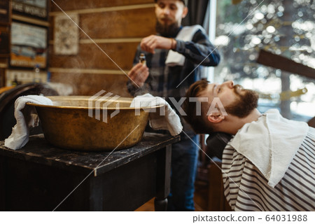 Barber soaks the towel, beard cutting, barbershop 64031988