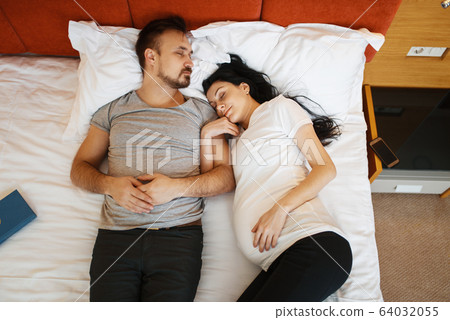 Husband and pregnant wife with belly are sleeping Husband and pregnant wife with belly are sleeping 64032055
