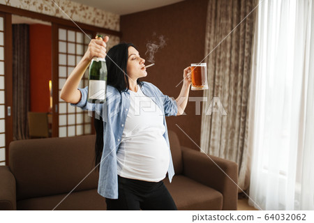 Pregnant woman with belly smoking and drinks wine Pregnant woman with belly smoking and drinks wine 64032062