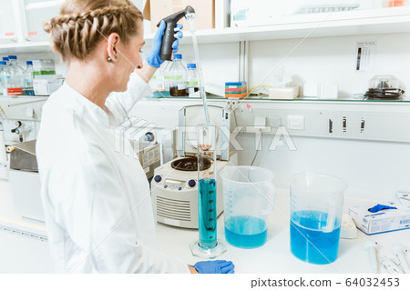 Woman doctor testing chemicals in lab Woman doctor testing chemicals in lab 64032453