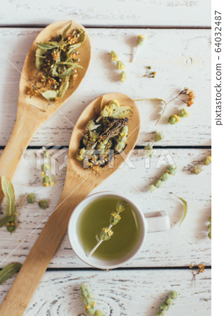 Natural organic herbal green tea in wooden spoons. 64032487