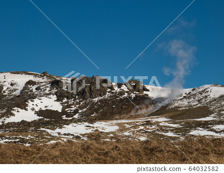 Steam cloud from the thermal springs in Iceland 64032582