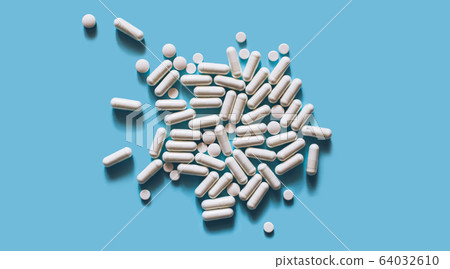 White medical pills on blue background.  64032610