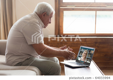 70s father talking with 60s daughter by videocall using laptop 64033994