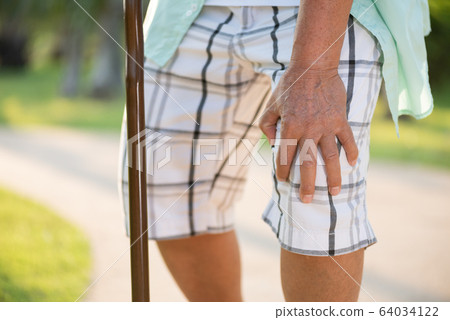 Asian old man sitting on sofa and having knee 64034122