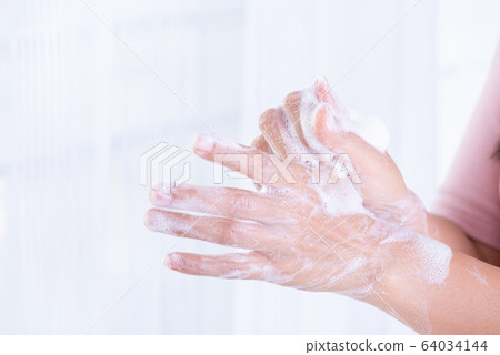 Closeup woman washing hands with soap on white Closeup woman washing hands with soap on white 64034144