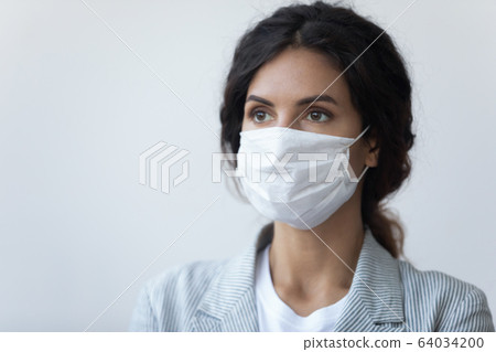 Serious lady wearing medical mask, protecting breath from air pollution. Serious lady wearing medical mask, protecting breath from air pollution. 64034200