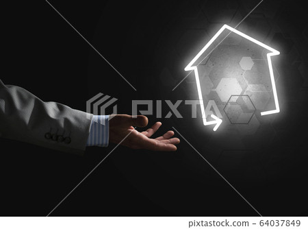 Conceptual image with hand pointing at house or main page icon on dark background 64037849
