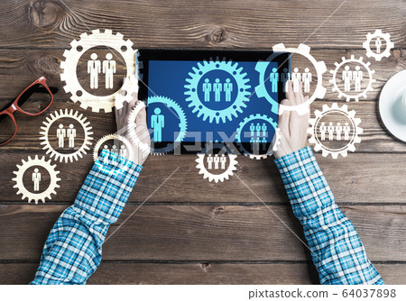 Concept of teamworking and connection with gears mechanism and tablet pc Concept of teamworking and connection with gears mechanism and tablet pc 64037898