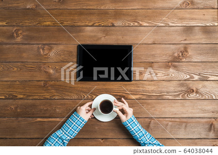 Top view of student sitting at wooden table and hold a cup of coffee Top view of student sitting at wooden table and hold a cup of coffee 64038044