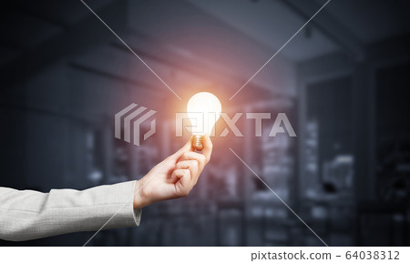 Human hand with glowing incandescent lamp 64038312