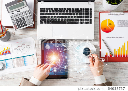 Businessman working at office desk with data Businessman working at office desk with data 64038737