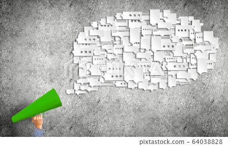 Hand of man holding green paper trumpet against concrete background Hand of man holding green paper trumpet against concrete background 64038828