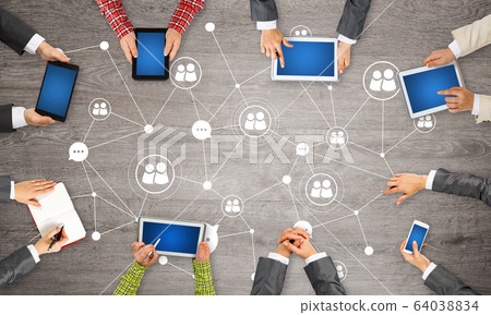 Top view of businesspeople sitting at table and using gadgets Top view of businesspeople sitting at table and using gadgets 64038834