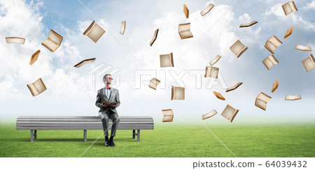 Young businessman or student studying the science and books fly around 64039432